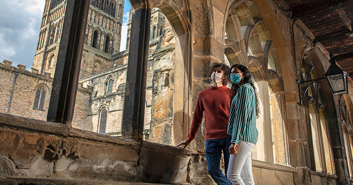 couple with masks on inside Durham Cathedral Cloisters 